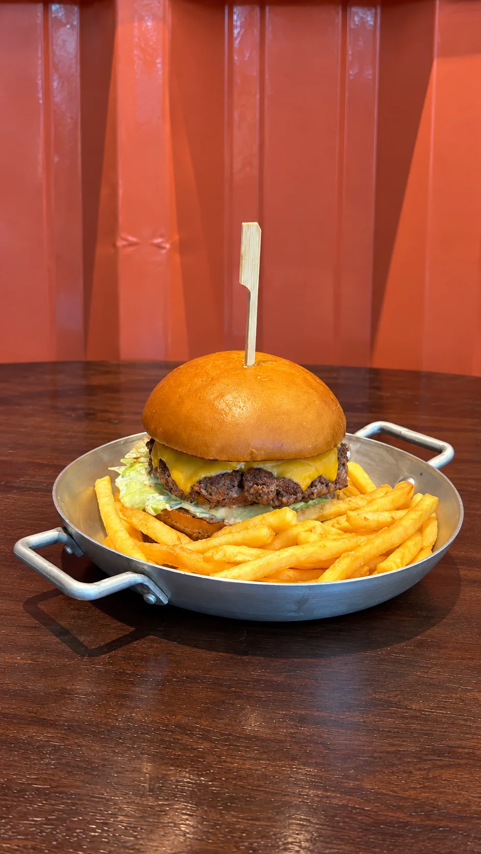 Hambúrguer do Lollos com cheddar e fritas, servido na frigideira